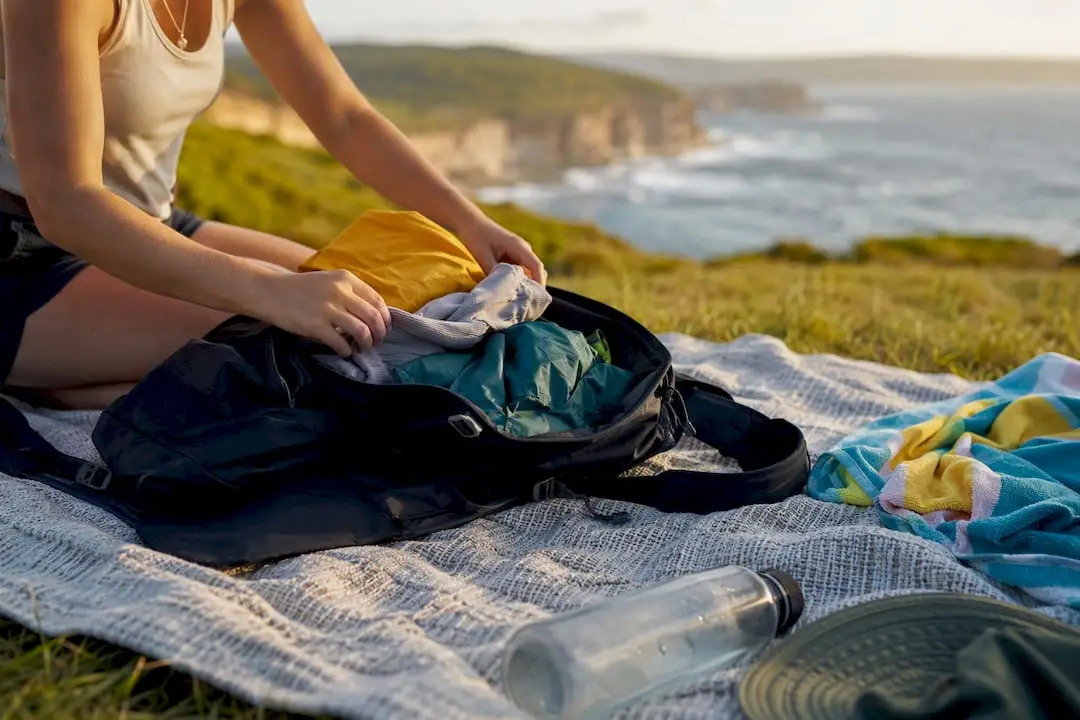 Hands packing layered travel clothes